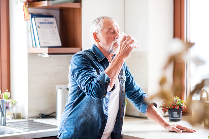 Older man drinking water.