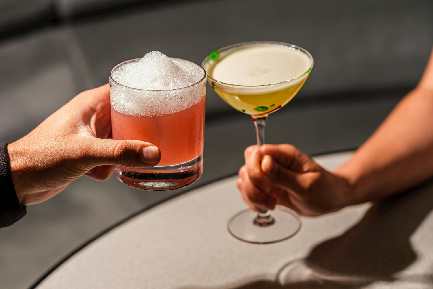Two people holding cocktails.