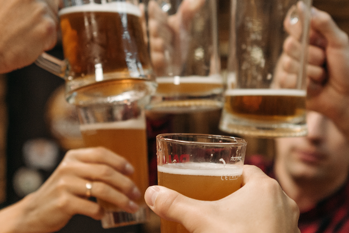 Group of friends clinking beer glasses with mindful drinking balance