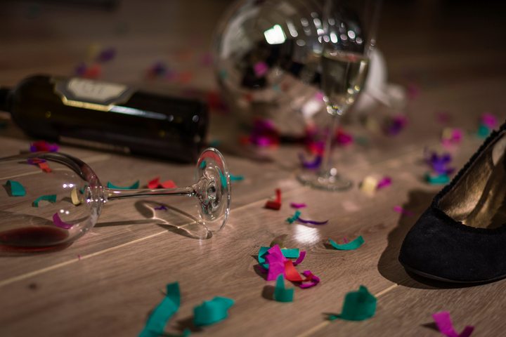 Empty wine glasses and confetti on the floor after a party, showing the need for the best remedy for hangover.