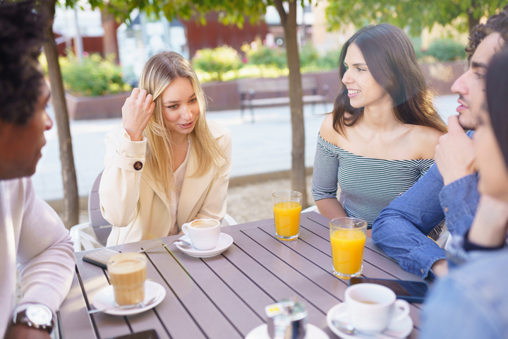 A group of young adults talking and drinking non-alcoholic drinks